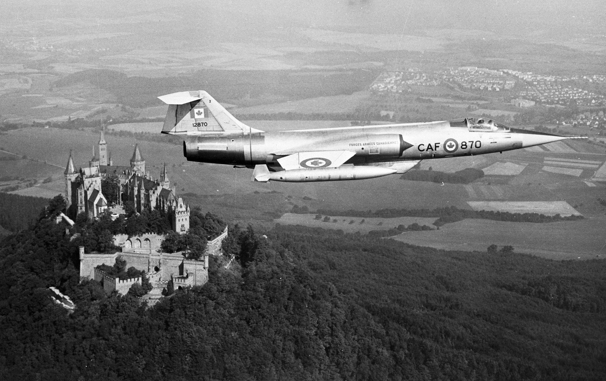 Un CF-104 Starfighter de la 1re Division aérienne du Canada, affectée à l’OTAN, vole près du château de Hohenzollern en République fédérale d’Allemagne. La Division aérienne, basée en Allemagne, comptait six escadrons de cet avion à réaction. PHOTO : Archives du MDN, IL69-64-1